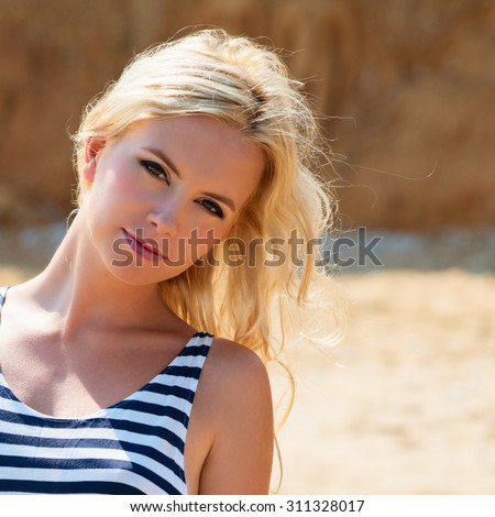 Portarait of young beautiful with long blonde hair, slim tanned body,  thin nose. sexy woman on the seashore sand. Photo with instagram style filters