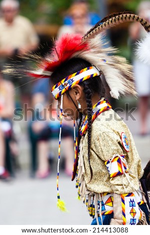 BANFF, CANADA - JUL 3: A young native Blackfoot Indian dancer performs her native dance during the Banff Summer Arts festival July 3, 2014. The Festival is the longest running arts festival in Canada.