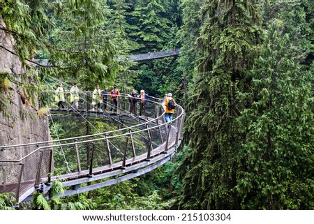 VANCOUVER, BRITISH COLUMBIA -JUN 29: Visitors exploring the Capilano Cliff Walk through rainforest June 29, 2011. The popular suspended walkways juts out from the granite cliff face 230 metres above the Capilano River.