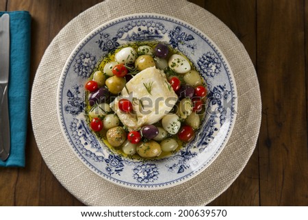 A typical Portuguese dish with codfish called Bacalhau do Porto in a original portuguese plate seen from above