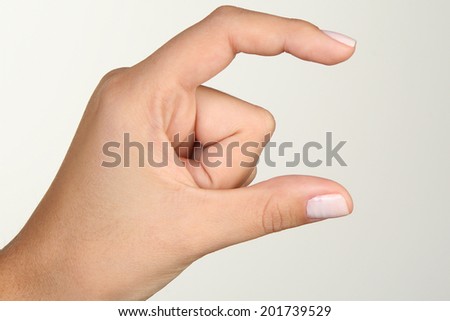 Woman\'s hand. Hand gesture meaning something small
