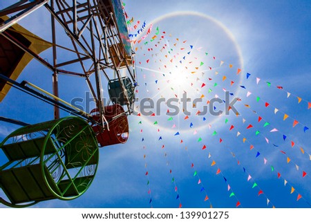 fantastic beautiful sun halo in midday thailand with ferris wheel