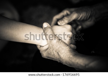 mom\'s hand hold her daughter\'s hand. centre focus. black and white.