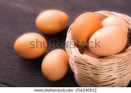 Fresh Eggs in basket on wood table.