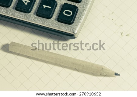 Business concept, pencil and calculator on graph paper. Retro filter