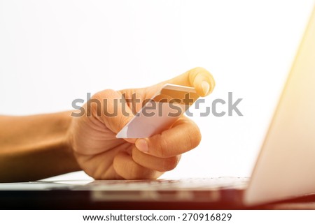 Internet of things, Shopping online, business online. Hand holding credit card doing business on line with laptop PC. Vintage filter.