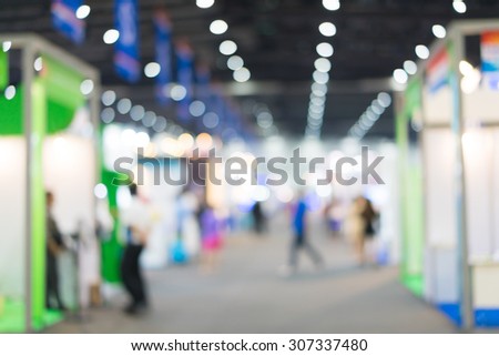 Blur of people in exhibition hall event.