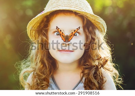 Surprised girl with a butterfly on her nose, focus on a girl\'s face. Background toning to instagram filter.