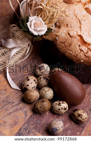 Italian Food for Easter - Easter still life with quail eggs, chocolate egg  and Easter dove on wood table.