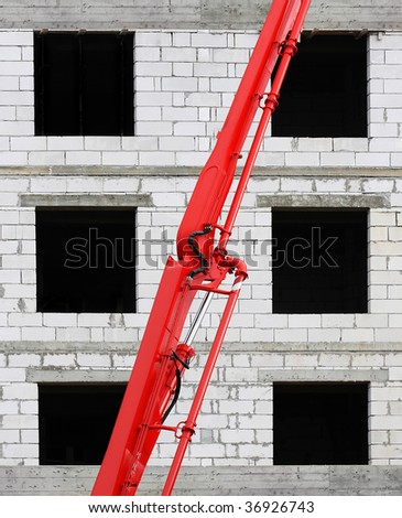 red crane in front of a brick building