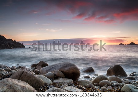The sun sets over Porth Nanven Cove near Penzance in Cornwall, also known as Cot Valley
