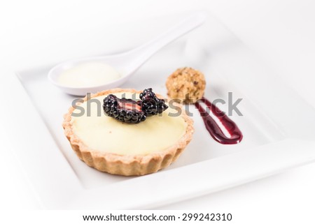 Gourmet Dessert. Cream-tart with black berry and berry coulis sauce