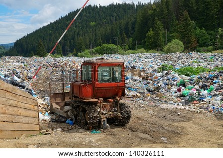 Old bulldozer at working landfill site (nature pollution in Carpathian mountains, Ukraine)