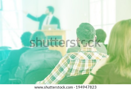 Speaker at conference giving presentation. Audience at the conference hall filtered.