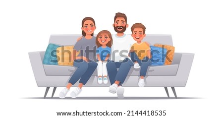 Happy family sitting on sofa over isolated background. Mom, dad, son and daughter are smiling while sitting on the couch. Concept of happiness and love, home comfort or watching a movie or telecast to
