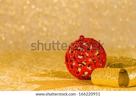 Christmas decorations: Red Christmas ornaments and golden ribbon on golden background