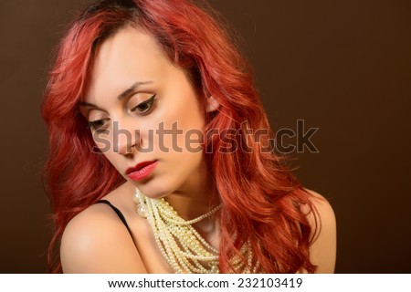 Portrait of a sad young woman looking down. studio shot on brown background