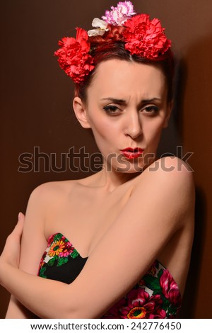 Fashion portrait of a redhead woman with flowers in hair. Attractive redhead woman. Close up portrait. Studio shot