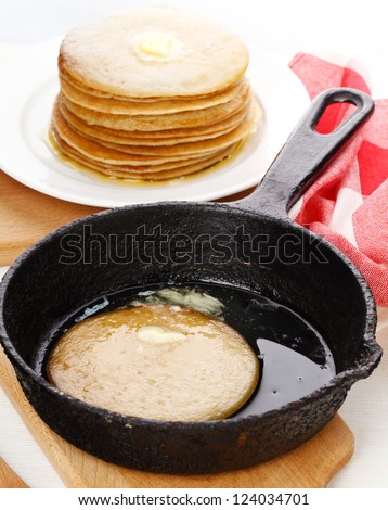 Pancakes on plate and pancake in pan on table