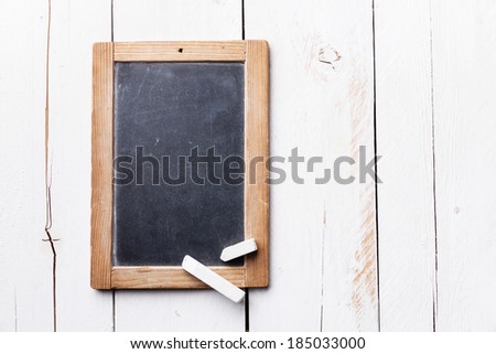 Vintage slate chalk board with chalk on white wooden background