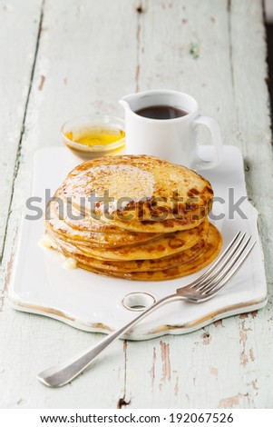 Stack of Small pancakes with butter and maple syrup