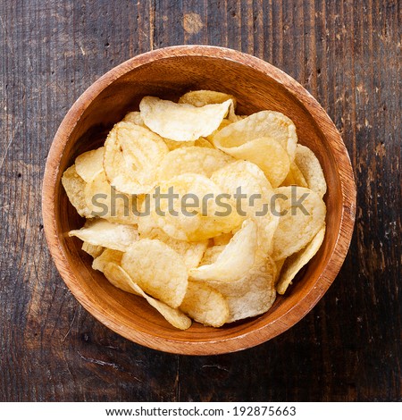 Crispy potato chips on wooden background