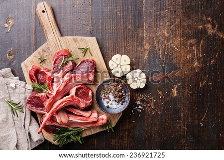 Raw fresh Lamb Meat ribs and seasonings on dark wooden background