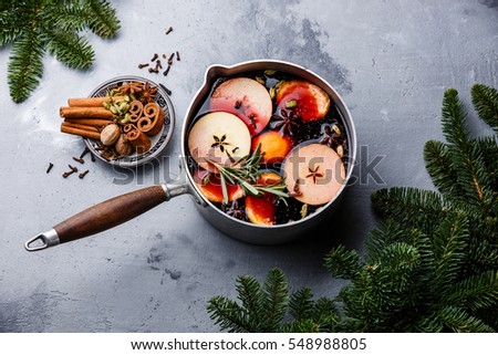Mulled wine hot drink with citrus, apple and spices in aluminum casserole and Fir branch on concrete background Сток-фото © 