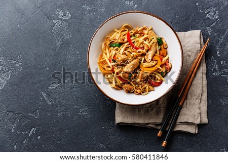 Udon stir-fry noodles with chicken meat and sesame in bowl on dark stone background copy space Foto d'archivio © 