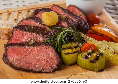 Grilled beef steak on wooden board on a light background restaurant