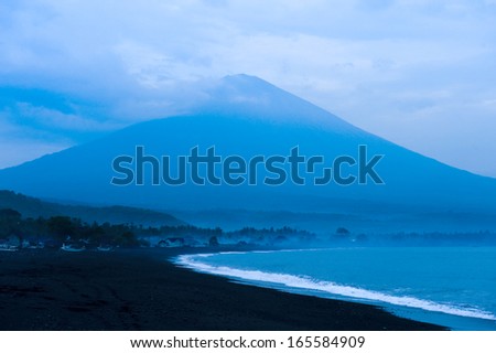 Bali, Indonesia. The active volcano, Gunung Agung, looms large over the fishing village of Jemeluk in the eastern part of this tropical island. This area is fast becoming a new tourist destination.