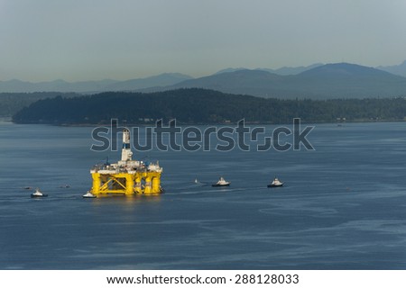 Off Shore Oil Rig. Tug boats escort an off shore oil drilling rigs as it leaves Seattle, Washington to return to Alaska.