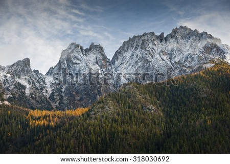 North Cascade Mountain Range. The larch trees changing color and the first dusting of snow signal the arrival of autumn along the beautiful North Cascades Highway or Highway 20.