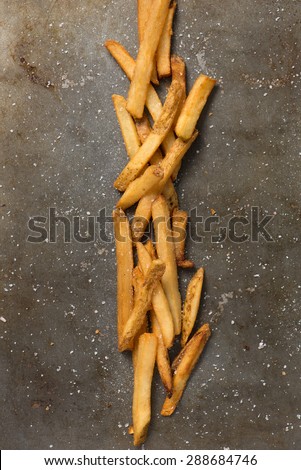french fries and sea salt styled in a baking pan, top view, close up, vertical