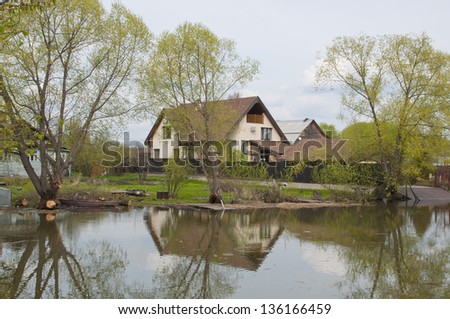 Old wooden house in the Russian tradition on the banks of the river in the village