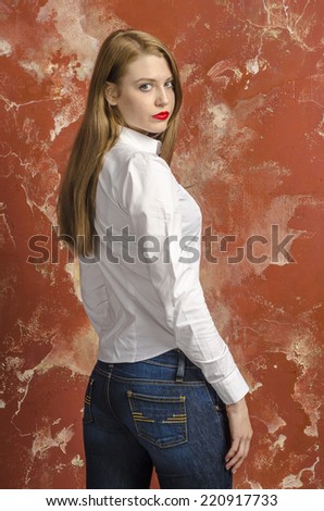 Young slim beautiful young blond woman with long legs and hair in Bedlam shirt and jeans