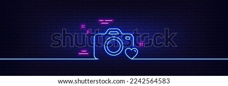 Neon light glow effect. Photo camera line icon. Love photography sign. Heart symbol. 3d line neon glow icon. Brick wall banner. Photo camera outline. Vector