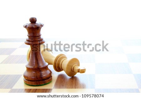 Two wooden chess pieces alone on a chess board.