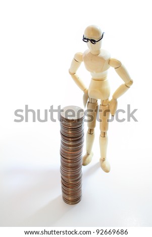 Wooden male figure staring at a stack of US quarters.