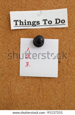 Blank to do list note pinned to a cork bulletin board with a giant push pin.