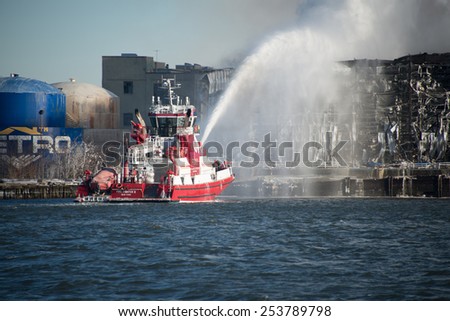 BROOKLYN, NY/USA - JANUARY 31 2015: The FDNY\'s fireboat Fire Fighter II pumps a stream of water onto the massive warehouse fire on the Williamsburg, Brooklyn waterfront.