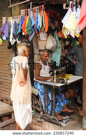 KOLKATA, INDIA - August 25: Old man sewing clothes in small workshops in the street of old city on August 25, 2015 in Calcutta.