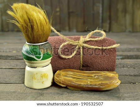 Vintage shaving still life with old shaving brush, brown towel and hand made soap bar