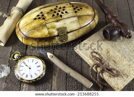 Retro still life with pocket watch, box and notepad on wooden planks