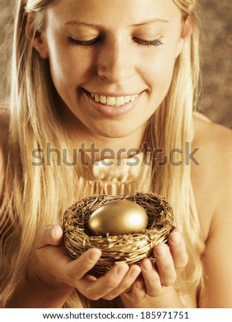 Mid-Adult Woman Holding Nest with Golden Egg