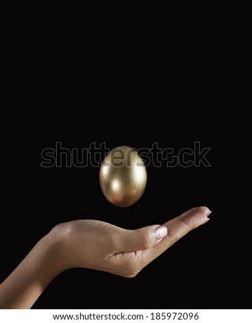 Golden Egg Above Woman\'s Hand