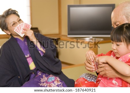 grandparents and girl playing cards