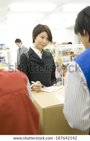 woman ordering for home-delivery service at convenience store