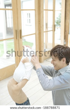 boy having his clothe taken off by father