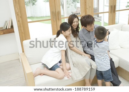 boy showing parents and elder sister a camera